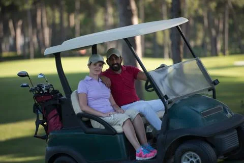 Couple in buggy on golf course Fotos Stock