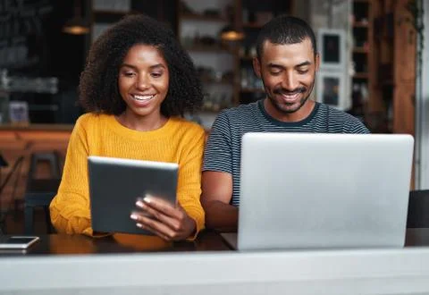 Couple busy in using electronic devices at café Stock Photos