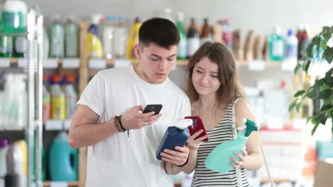 Couple buyer scans qr code on tile cleaner spay label Stock Footage 314764364