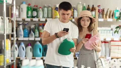 Couple buyer scans qr code on laundry conditioner label Stock Footage 327694972
