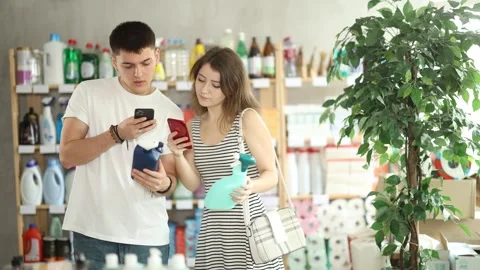 Couple buyer scans qr code on tile cleaner spay label Stock Footage 329396733