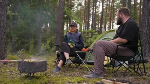 Couple camping in forest talking and grilling food Stock Footage 327132463
