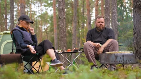 Couple camping in pine forest having a barbecue Stock-Footage 327133027