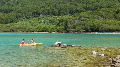 A couple canoeing stops on a beach for a break Stock Footage 259195324