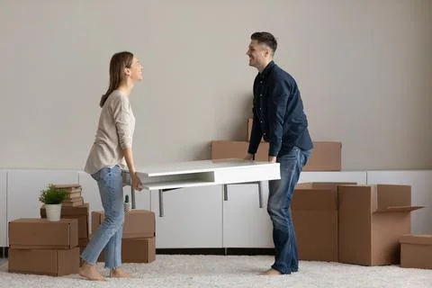 Couple carrying table to living room furnish house with furniture Stock Photos