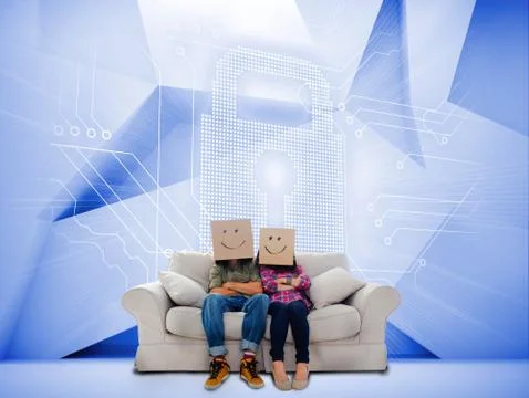 Couple with cartons on head sitting on couch under white holographic lock Stock Photos