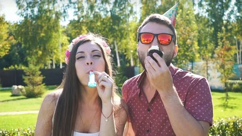 Couple celebrating and playing with party blowers Stock Footage
