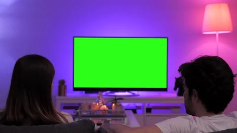 The couple chatting and watching movies on television green screen tv Stock Footage