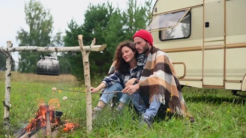 Couple in a checkered plaid roasting marshmallows on fire near the trailer home. Stock Footage 154141902
