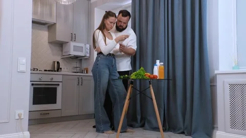 Couple checking grocery receipts and discussing nutrition in kitchen Video stock 320501047