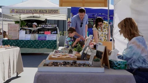 Couple checking items at vendor's booth, outdoor market, Kelowna BC Canada Stock Footage 278020682