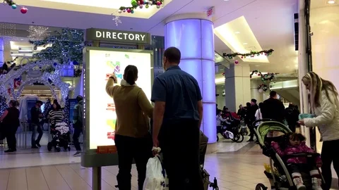 Couple checking store position in front of directory sign inside shopping mall Stock Footage 70998949