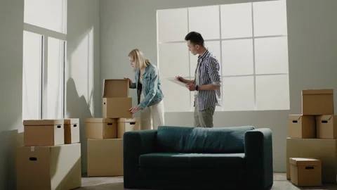 Couple checks large boxes holding tablet after relocation Stock Footage 151039120