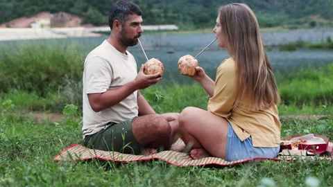 Couple cheers coconuts by shore. Stock Footage 288825807