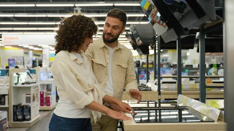 Couple choosing induction stovetop in electronics store Stock Footage 317723574