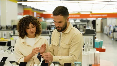 Couple choosing smartphone in electronics store on Black Friday Stock Footage 317725060