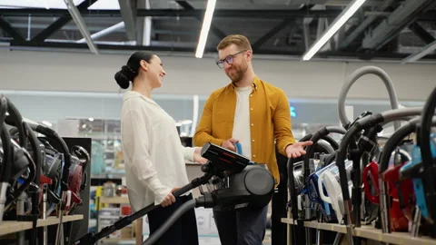 Couple choosing vacuum cleaner in an electronics store for new home Stock Footage 279638454