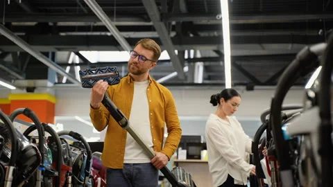 Couple choosing vacuum cleaner in an electronics store for new home Stock Footage 279639064