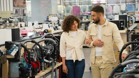 Couple choosing vacuum cleaner in electronics store Stock Footage 317729884