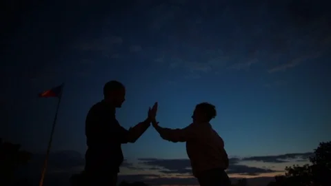 Couple clapping their hands against sunset Stock Footage 100158651