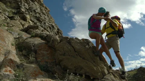 Couple climbing mountain range Stock Footage 68782503