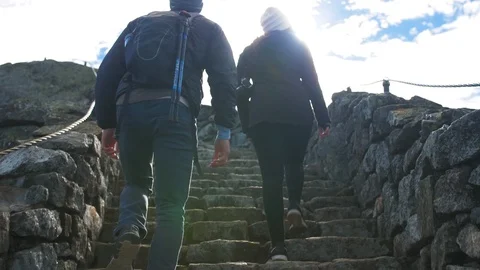 Couple Climbs Rock Steps Up Mountain, Lens Flare, Hiking Video stock 102401325