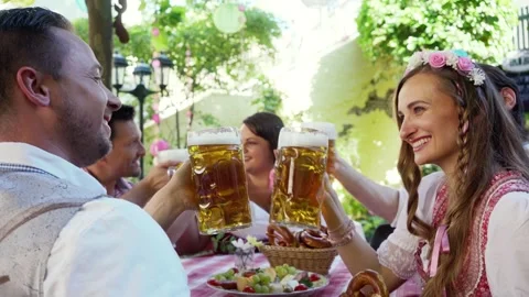 Couple clinking glasses with huge amounts of beer in Bavarian pub Stock Footage 243666424