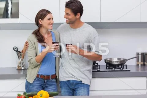 Couple clinking their glasses of red wine Stock Photos