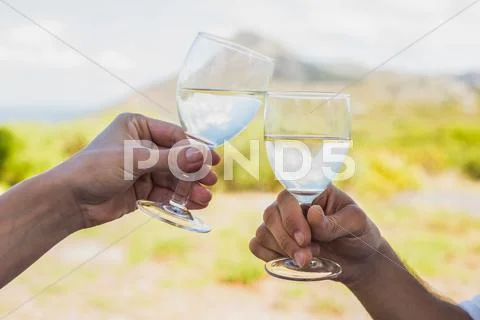 Couple clinking wine glasses outside Stock Photos