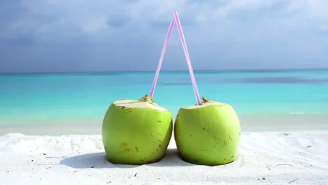 Couple of coconuts on white sand and blue ocean background Stock Footage 140581188