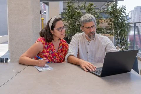 Couple collaborating remotely using laptop on terrace Stock Photos