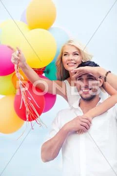 Couple with colorful balloons at seaside Stock Photos