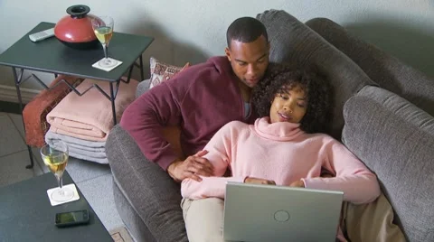 Couple with computer on couch Video stock 7730427