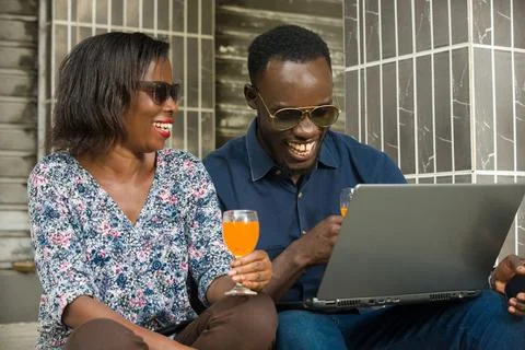 Couple connected to a computer and drinking fresh drink Stock Photos