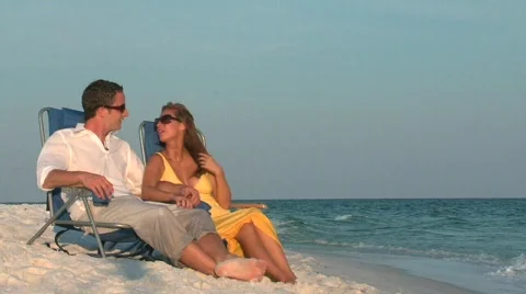Couple conversing in chairs on beach Stock Footage 299377