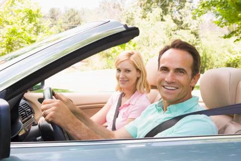 Couple in convertible car smiling Stock Photos