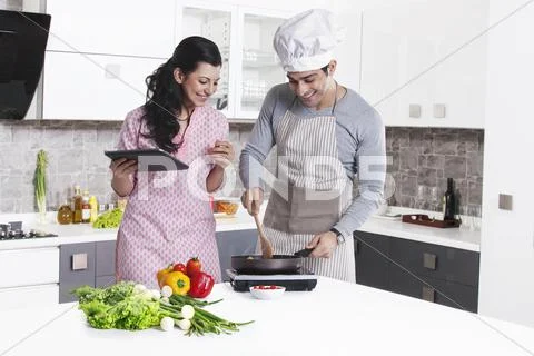 Couple Cooking In Kitchen