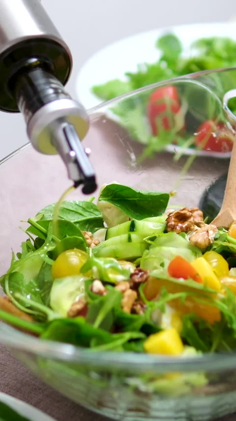 Couple cooking in the kitchen. womans hand preparing salad for dinner. Close up Video stock 296089017
