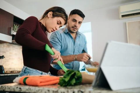 Couple Cooking Together Watching Tutorial For Recipe Stock Photos