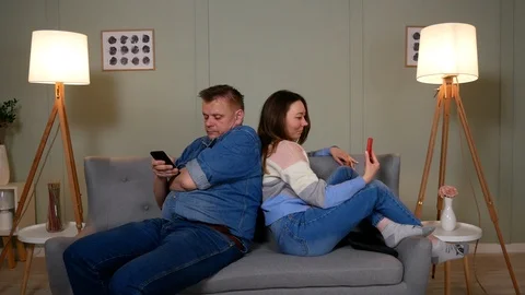 Couple on the couch play games from a mobile phone Video stock 126853260
