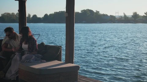 Couple covered with blanket having fun by the river Stock Footage 99976396