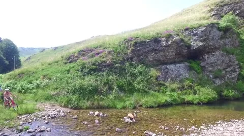 Couple crossing river stream in mountains with bikes Stock Footage 65511586
