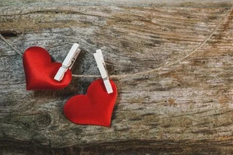 Couple of cute red hearts on string with pegs on wooden background. Romantic Stock Photos