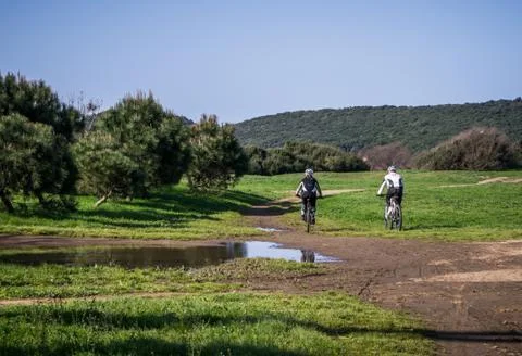 Couple of cyclist across a meadow Stock Photos