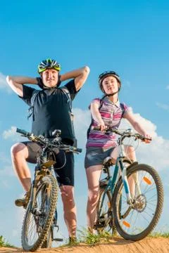 A couple of cyclists in helmets on bikes posing Stock Photos