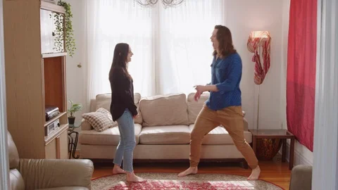 Couple dances to music from record playing in background - slow motion Stock Footage 129853879