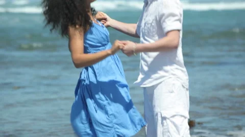 Couple dancing and playing in surf at beach Video stock 62279984