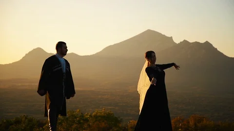 Couple dancing on a background of mountains at sunset Caucasian dance. Stock Footage 129973990