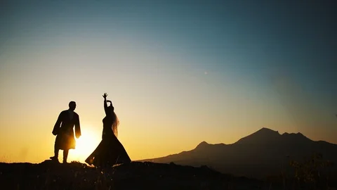 Couple dancing on a background of mountains at sunset Caucasian dance. Stock Footage 129974012
