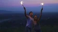 The couple dancing with firework sticks on a night city background. slow motion HD Footage